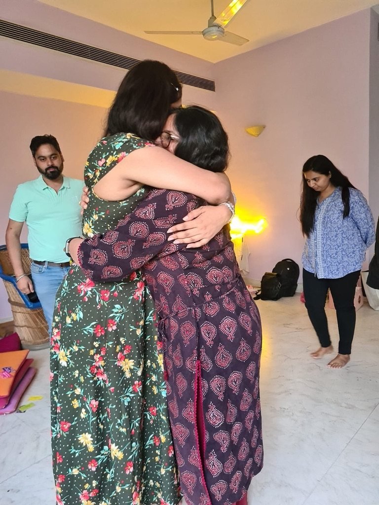 Two participants holding each other at a Heartfullness workshop in Delhi